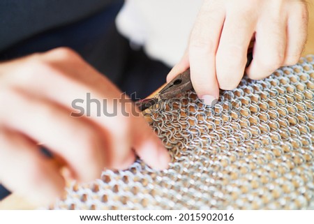 Detail of unrecognizable person using pliers while crafting chain-mail Royalty-Free Stock Photo #2015902016