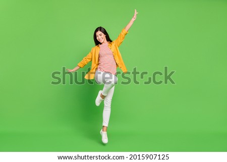 Full size photo of cool brunette millennial lady jump wear shirt trousers isolated on green color background Royalty-Free Stock Photo #2015907125