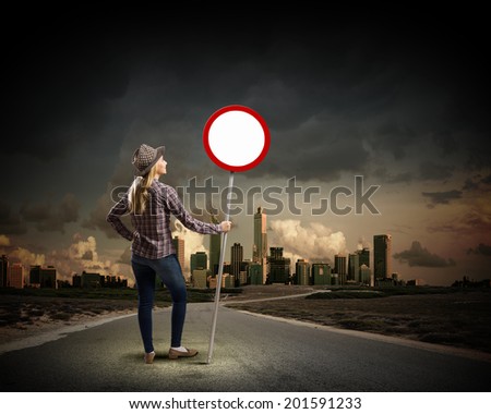 Young woman in casual holding road sign