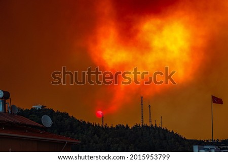 Massive Forest Fire in Manavgat Turkey, fire fumes, smoke in the city, flames are rising to the sky, Dramatic Sunrise in smokes. Royalty-Free Stock Photo #2015953799