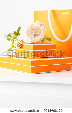 Different Yellow boxes with paper shopping bag  and white peony flower on the table. Making gift concept.