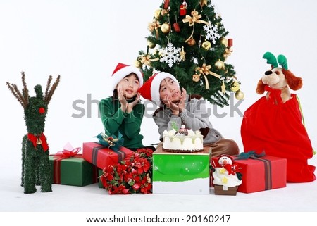 Xmas Kids sitting and playing with Christmas gifts on white background