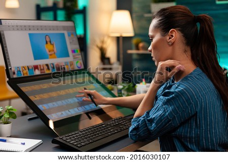 Studio editor doing retoucher work on touch screen computer monitor for occupation. Artist sitting at professional desk working with modern technology photography software and stylus