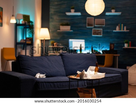 Garbage covered house apartment of alone woman with mental depresion having trash, rubbish with no people in. Unorganized empty living room of depressed person with scattered food mess, disorder table Royalty-Free Stock Photo #2016030254
