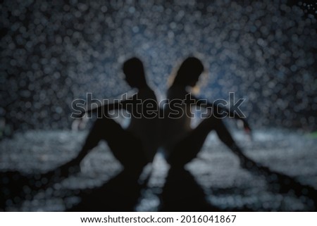 Defocused abstract background of couple down in rain at night