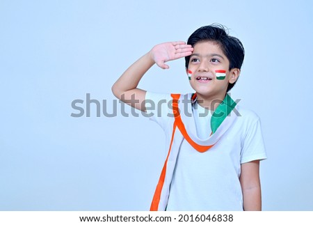 Little boy saluting wearing white kurta pajamas on the occasion of Indian Independence day celebration Royalty-Free Stock Photo #2016046838