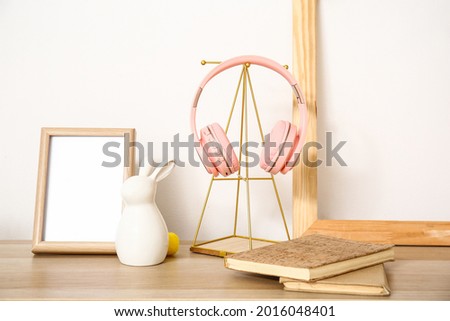 Modern headphones with notebooks and stylish decor on table in room
