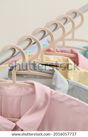 Pastel women shirts hanging on rack in shop