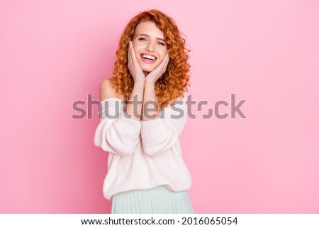 Photo portrait of curly girl laughing touching cheeks overjoyed in stylish outfit isolated pastel pink color background