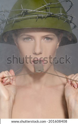 Woman in green military helmet with a token in smoke