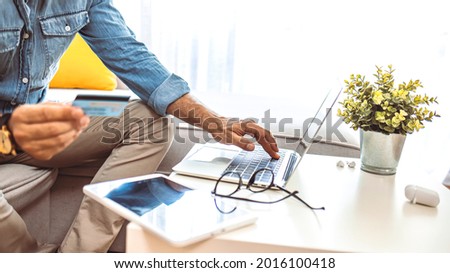 Modern technologies concept. Unrecognizable Mature man booking tickets online preparing for business trip, using smartphone and holding credit card. Copy space