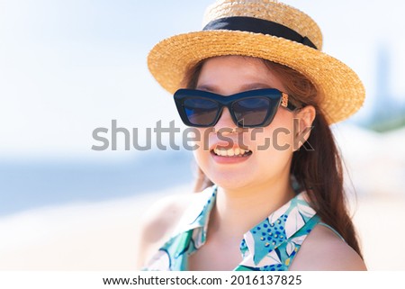 Beautiful woman wearing sunglasses outdoors on sunny day. Women wearing straw hat fashion. Happy summer time.