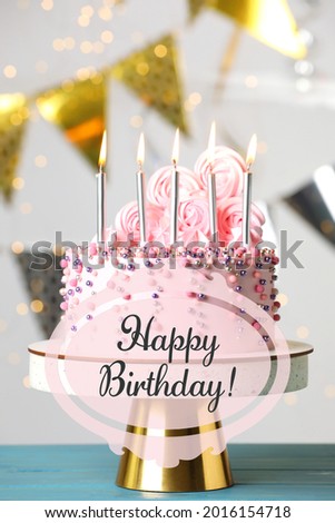 Happy Birthday! Delicious cake with burning candles on blue wooden table