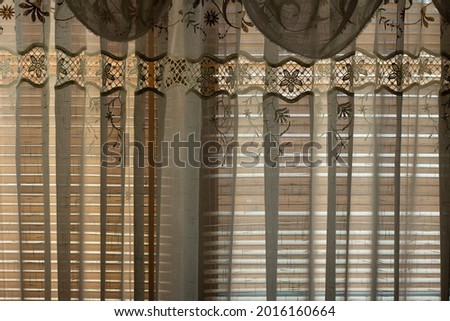The curtains on the window. Light tulle shades the light from the window. Lace curtains to protect against onlookers in the window.
