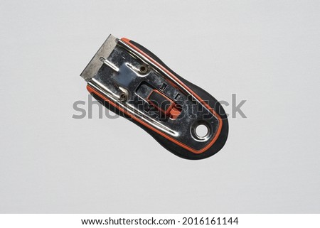 Cutter knife with orange and black handle on white background