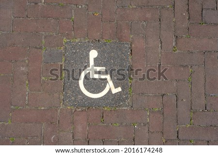 Logos for disabled on parking. handicap parking place sign on brick stones