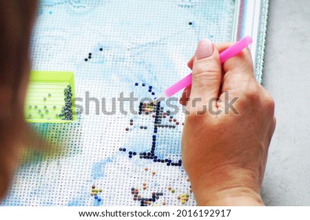A woman collects a diamond mosaic