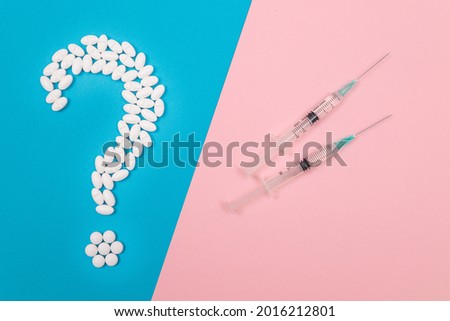 Vaccination Scepticism. Question Mark Made from White Pills and Tablets with Medical Syringe, Lying on Split Blue and Pink Background. Global Pharmaceutical Industry and Medicinal Products