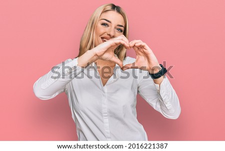 Young caucasian woman wearing casual clothes smiling in love doing heart symbol shape with hands. romantic concept. 