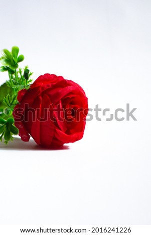 Fake red roses made of plastic and cloth on a white background