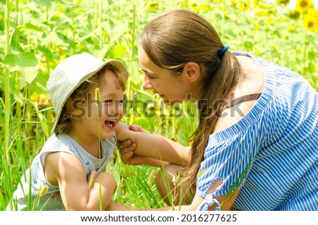 mother and baby in sunflowers field
