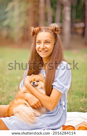 Teen girl with pet animal small dog on a picnic outdoor