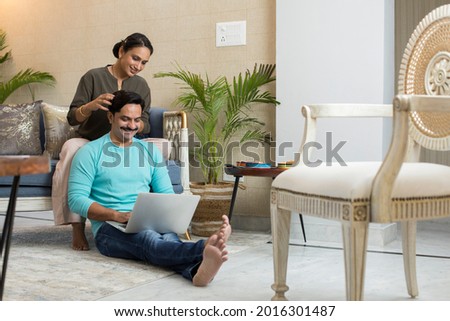Wife and husband spend time with laptop at home.