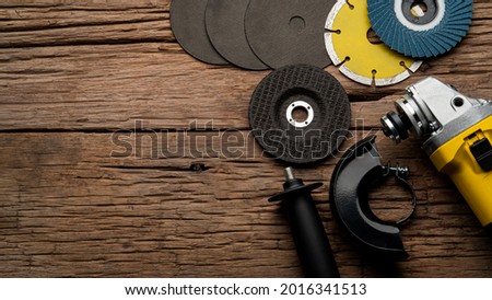 Set of angle grinder with grinding wheel,Metal Cutting Wheel,diamond cutting and flap disc on wooden plate with copy space