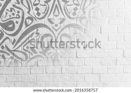 Arabic Calligraphy Wallpaper on a White Wall Background Interlocking Translation "Interlocking Arabic Letters" Royalty-Free Stock Photo #2016358757
