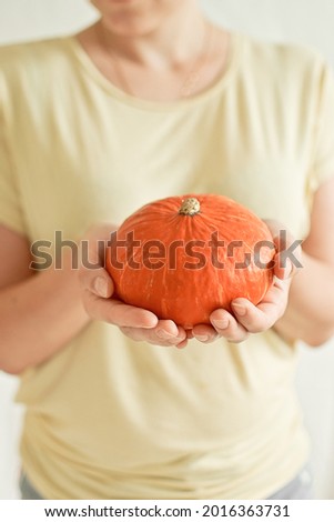 Woman holding pumpkin on white background. Fall autumn concept.Ripe vegetables from garden. Harvest festival. Thanksgiving or Halloween. Greeting card or banner for sales. Selective focus