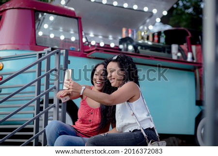 A sisters taking a selfie with their smartphone