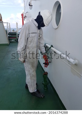 a ship crew is taking sounding of a ballast tank for draft survey calculation on aboard a cargo ship or bulk carrier. Royalty-Free Stock Photo #2016374288