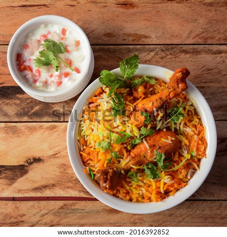 Traditional Hyderabadi Chicken dhum Biryani made of Basmati rice cooked with masala spices, served with raita, selective focus Royalty-Free Stock Photo #2016392852