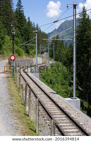 Railroad tracks in the mountains between mountain village Mürren and Winteregg on a sunny summer day. Photo taken July 20th, 2021, Lauterbrunnen, Switzerland.