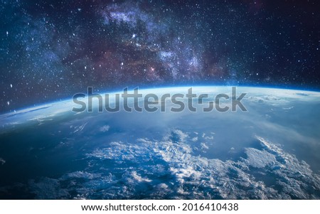 Earth in the outer space. Orbit of planet. Sun light and stars on background. Milky way. Elements of this image furnished by NASA Royalty-Free Stock Photo #2016410438