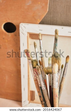 brushes, canvases and palette against the wall, artist's workshop concept