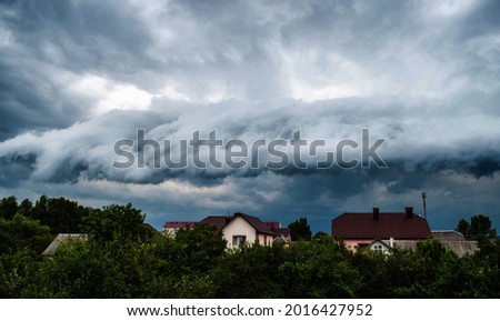 Thunderstorm clouds over a small town. Approaching storm front. Royalty-Free Stock Photo #2016427952