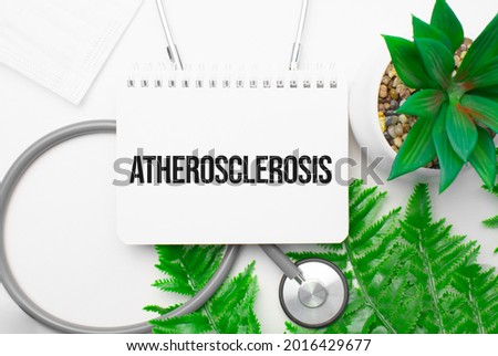 Atherosclerosis word on notebook,stethoscope and green plant