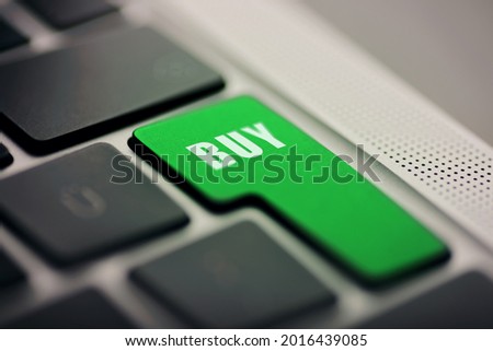 Close up shot of Enter button laptop computers enter button with Buy text written on green.