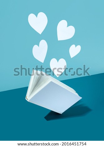 Floating Cute paper heart and white cover book on bold color blue-aquamarine-turquoise background. Modern photo. Concept National Book Lovers Day. happy holydays. love storytelling.copy space. Mock up Royalty-Free Stock Photo #2016451754