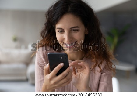 Happy millennial Hispanic woman hold smartphone look at screen speak talk on video webcam virtual call online. Smiling young Latino female use cellphone text message on modern electronic device. Royalty-Free Stock Photo #2016455330
