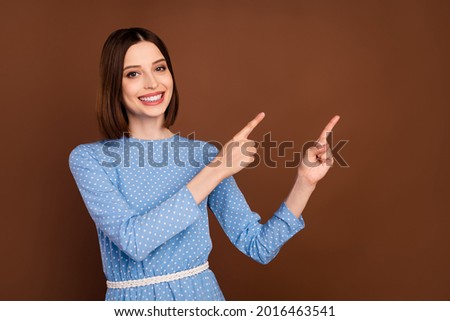Photo of optimstic short hairdo young lady point empty space wear blue blouse isolated on brown color background