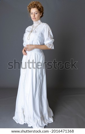 An Edwardian woman wearing a white lace blouse and skirt  Royalty-Free Stock Photo #2016471368