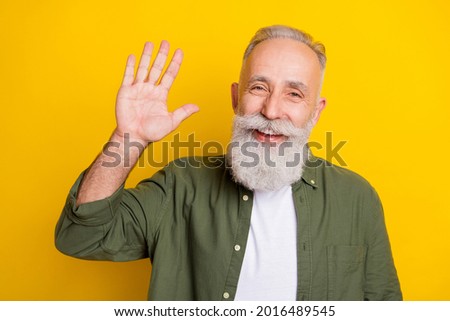 Photo portrait of grandfather smiling happy waving hand greeting isolated bright yellow color background Royalty-Free Stock Photo #2016489545
