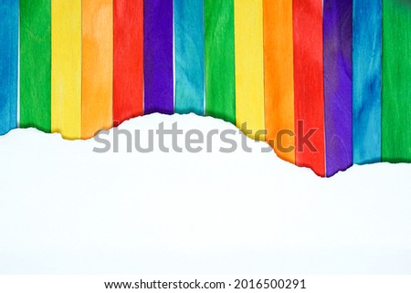 pride month background concept with ripped white mock up paper on colorful popsicle sticks,LGBTQ colors for background, rainbow colors,Pride community, flat lay and copy space concept. Royalty-Free Stock Photo #2016500291