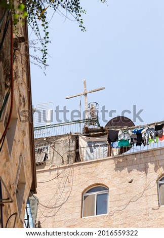 Large wooden cross and statue of the Virgin Mary on the roof on the quiet small AR Rusul in Christian quarters in the old city of Jerusalem, Israel