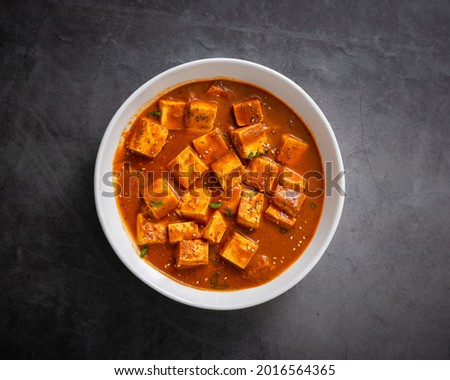 A vertical shot of traditional Indian paneer butter masala or cheese cottage curry on a black surface Royalty-Free Stock Photo #2016564365