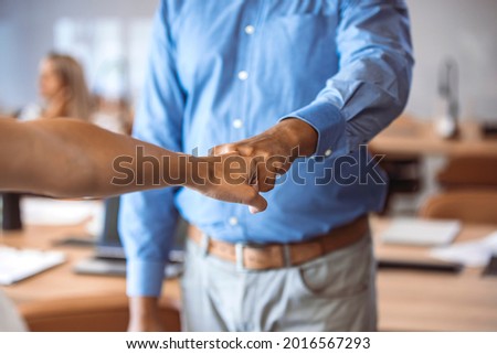 Partner trust business partnership mission deal. Businessman fist bumping with a colleague in the office. Close up of businessmen fist bumping in the office. 