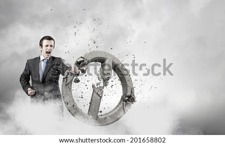 Angry determined businessman crashing stone prohibition symbol