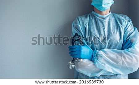 Medical worker portrait without face dressed in disposable medical gown and protective mask Royalty-Free Stock Photo #2016589730